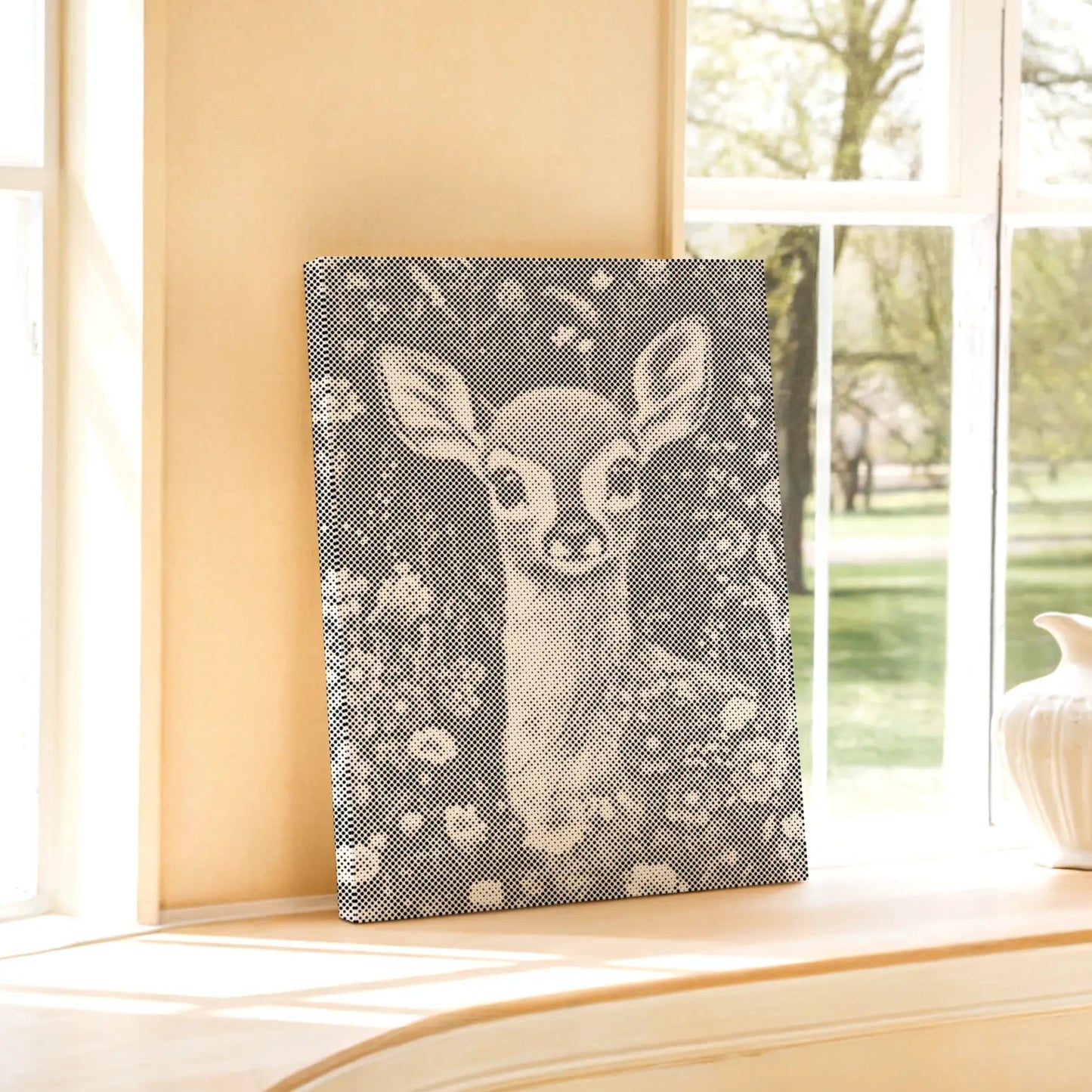 Canvas print of a deer in a floral pattern on a windowsill with a view of trees outside. Dot Painting Kit Fawn – Quiet Meadow | Paint by Dots