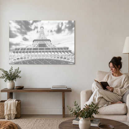 Dot-painting canvas “Eiffel Tower”, on a living-room wall with a person reading in an armchair nearby.