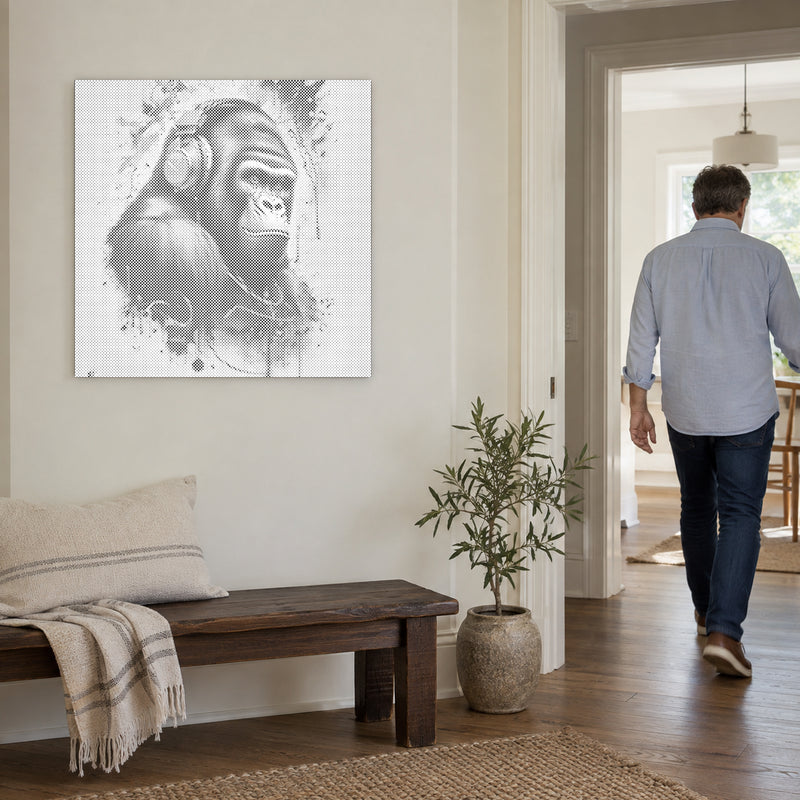 Dot-painting canvas “Gorilla with Headphones”, on a light wall with a person walking through the doorway nearby.